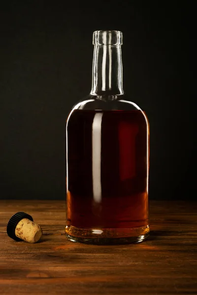 Otwarta Butelka Alkoholu Korkiem Drewnianym Stole Ciemnym Tle — Zdjęcie stockowe