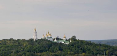 A very ancient monastery on a mountain, against the backdrop of greenery and sky
