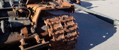 Yanmış ve parçalanmış tank ön taraftan fotoğraflandı.