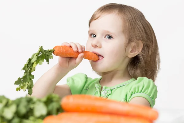 Criança come uma cenoura Fotografias De Stock Royalty-Free