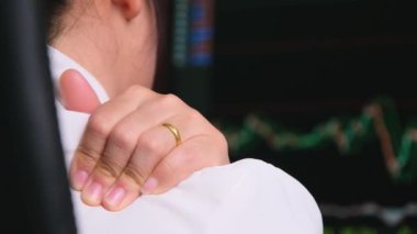 Tired woman massaging shoulders with tensed muscles, fatigued from working at a computer. Woman suffering from shoulder pain in office