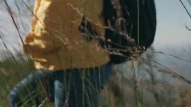 Sırt çantalı mutlu hippi kadın sonbaharda ormanda yürüyüşe çıkıyor. Sağlıklı ve aktif bir Asyalı kadın gezgin dağın zirvesinde doğa yürüyüşü yapıyor..