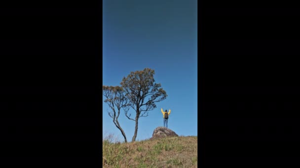 バックパックを持つ幸せなヒップスター女性日の出で澄んだ空に対して山の上で日の出を楽しむ — ストック動画