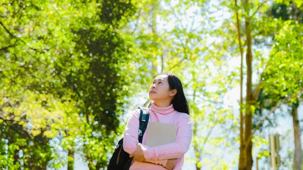 Asiática Estudiante Con Mochila Sosteniendo Libro Mirando Hacia Otro Lado —  Fotos de Stock