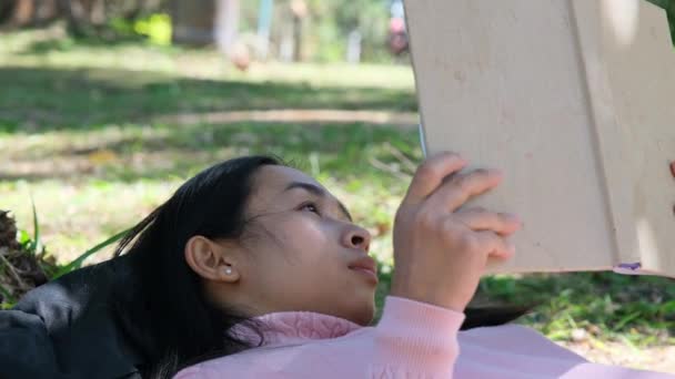 Asian Female College Student Lies Large Tree Reading Book University — Stock Video