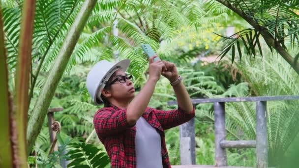 Environmental Engineer Wears Helmet Analyzes Plants Smartphone Social Network Forest — Stock Video