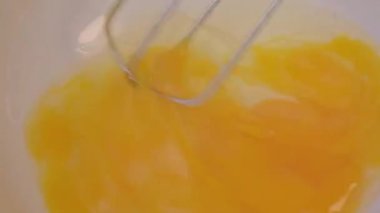 Sabah ev yapımı omlet hazırlayan bir tel çırpıcıyla bir kasede yumurta çırpmak. Kahvaltı hazırlıyorum. Sağlıklı gıda konsepti.