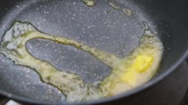 Sıcak tavada tereyağı ısıtmak ve eritmek. Aşama aşama omlet yapma süreci. Kahvaltı hazırlıyorum. Sağlıklı gıda konsepti.