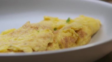 Beyaz tabakta doğranmış taze soğan serpiştirilmiş omlet. Sağlıklı gıda konsepti. Kahvaltı hazırlıyorum..