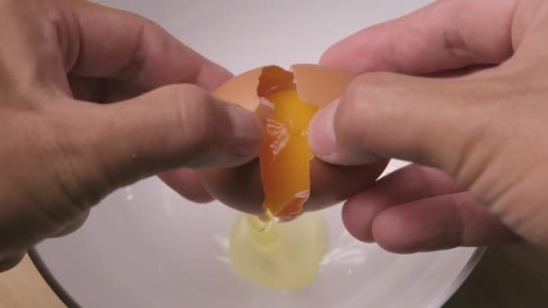 Αργή Κίνηση Ενός Χεριού Σπάει Ένα Αυγό Ένα Άσπρο Μπολ — Αρχείο Βίντεο