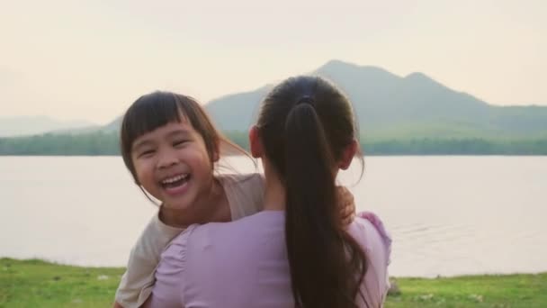 Madre Sosteniendo Una Linda Hijita Caminando Por Lago Atardecer Niña — Vídeo de stock