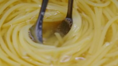 Spagettiyi tabağa döken sosun yakın çekimi. Makarnanın içine yoğurt sosu dökülüyor. Evde yemek pişirmek. Ev yapımı Carbonara spagettisi.