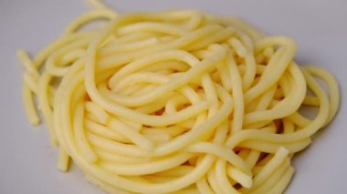 Spagettiyi tabağa döken sosun yakın çekimi. Makarnanın içine yoğurt sosu dökülüyor. Evde yemek pişirmek. Ev yapımı Carbonara spagettisi.