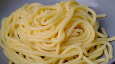 Makarnayı bir tabaktan carbonara sosuyla alan çatala yakın çekim. Çatallı sıcak spagetti. İtalyan Mutfağı ve Ev Yemekleri Konsepti