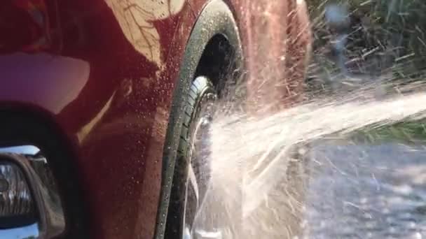 Close Water Flowing Car While Worker Using High Pressure Washer — Stockvideo