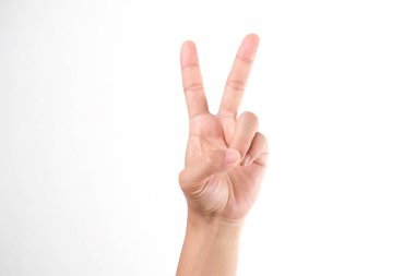 Beyaz arka planda zafer işareti gösteren kadın eller, yaklaşın. Kadın elleri barış işareti yapıyor.