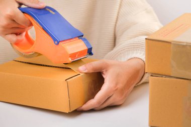 Küçük işletme sahipleri iş yerinde karton kutular paketliyorlar. Genç iş kadını onun mağazasında online e-ticaret alışverişinde çalışıyor. Küçük işletme girişimcisi, KOBİ veya Serbest