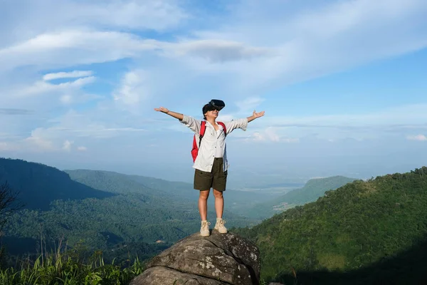 快乐的冒险家女人戴着Vr耳机 在美丽的山水景观的概念中增强了现实的真实感 年轻女子戴着虚拟现实眼镜站在山顶上的悬崖上 — 图库照片