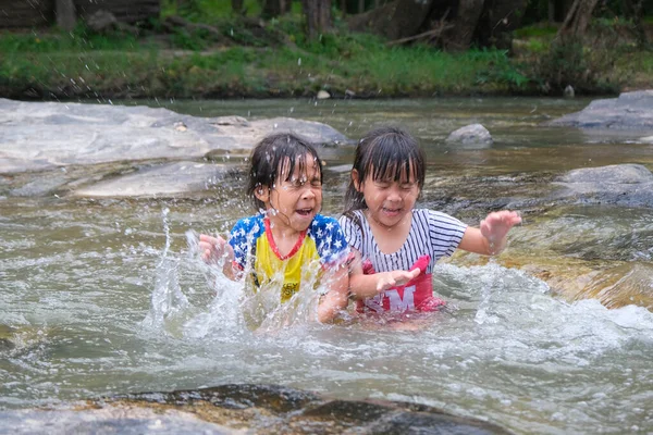 ストリーム内の水を再生幸せなかわいい女の子と彼女の妹 アジア系の妹は川で泳ぐのが好きだ 子供のための健康的な夏の活動 — ストック写真