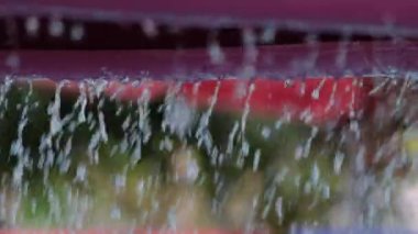 Close-up shot of water dripping from a mushroom-shaped fountain at a water park.