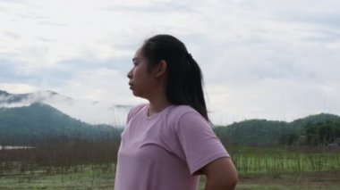 Asian women run in the countryside by the river in the morning and rest after training. Sports and recreation healthy lifestyle concept.