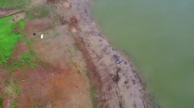 Old wooden boat on the bank of the river among the twigs waste  with calm rivers(Lam Taphen Reservoir), Kanchanaburi Province, Thailand. Aerial view from drone