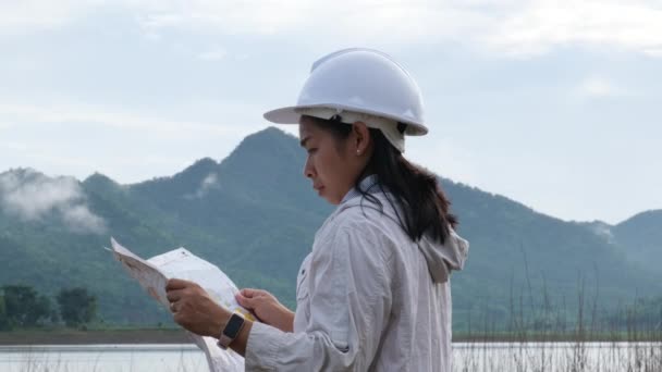 Engineering Ecologist Woman Helmet Holding Blueprint Stands Bank River Develop — Vídeo de stock