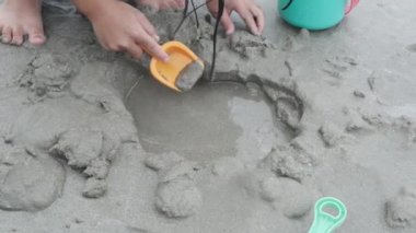 Cute little sisters playing with sand on the beach on summer holidays. Children building a sandcastle at sea. Travelling with kids