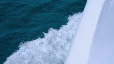 Denizde yelken açarken deniz dalgalarının görüntüsü. Motorlu bir tekneden sonra su dalgasına yakın çekim.