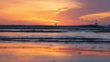 Beautiful sunset view on the beach. Colorful sea beach sunset with golden light reflected on the water surface and soft waves. Summer vacation and travel concept.