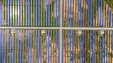 Aerial view of solar power plant on green field. Solar panels system for solar power generation. Green energy for sustainable development to prevent climate change and global warming to protect earth.
