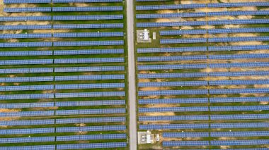 Aerial view of solar power plant on green field. Solar panels system for solar power generation. Green energy for sustainable development to prevent climate change and global warming to protect earth.
