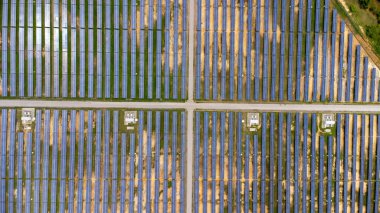 Aerial view of solar power plant on green field. Solar panels system for solar power generation. Green energy for sustainable development to prevent climate change and global warming to protect earth.