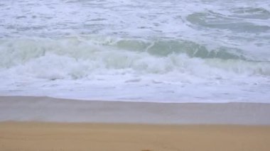 Okyanus dalgaları ve Tayland 'daki tropikal deniz sahillerinde kum. Şiddetli deniz dalgaları yağmur mevsiminde kıyıya vurur.