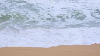 Okyanus dalgaları ve Tayland 'daki tropikal deniz sahillerinde kum. Şiddetli deniz dalgaları yağmur mevsiminde kıyıya vurur.