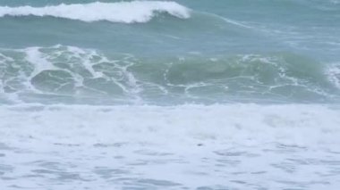 Okyanus dalgaları ve Tayland 'daki tropikal deniz sahillerinde kum. Şiddetli deniz dalgaları yağmur mevsiminde kıyıya vurur.