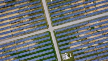 Aerial view of solar power plant on green field. Solar panels system for solar power generation. Green energy for sustainable development to prevent climate change and global warming to protect earth.