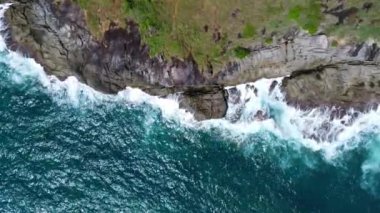 Mavi okyanustaki kayalıklara çarpan deniz dalgalarının hava görüntüsü. Phuket Okyanusu 'ndaki en yüksek kıyı kayaları manzarası. Sabahları Laem Phromthep Pelerini 'nin manzara manzarası.