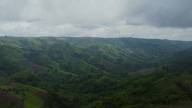 Bulutlu gökyüzü ile dağda enerji üretimi için yel değirmenlerinin hava manzarası. Tayland 'da Khao Kho rüzgar türbini tarlaları. Rüzgar türbinleri sürdürülebilir kalkınma için temiz yenilenebilir enerji üretir.