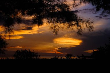 Beautiful sunset view on the beach. Colorful sea beach sunset with golden light reflected on the water surface and soft waves. Summer vacation and travel concept.