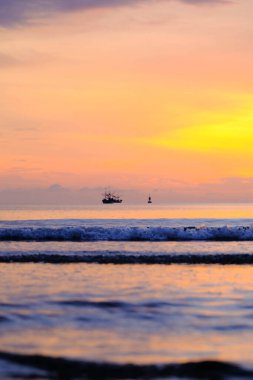 Beautiful sunset view on the beach. Colorful sea beach sunset with golden light reflected on the water surface and soft waves. Summer vacation and travel concept.