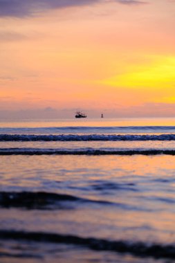 Beautiful sunset view on the beach. Colorful sea beach sunset with golden light reflected on the water surface and soft waves. Summer vacation and travel concept.