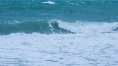 Tayland 'daki tropikal deniz sahillerindeki deniz dalgalarının görüntüsü. Şiddetli deniz dalgaları yağmur mevsiminde kıyıya çarpar. Mavi ve turkuaz rengi köpüklü güzel deniz dalgaları.