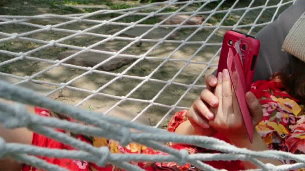 Žena relaxační s smartphone na houpací síť, full hd. — Stock video