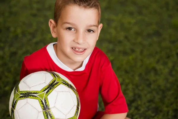 Jovem menino segurando futebol — Fotografia de Stock