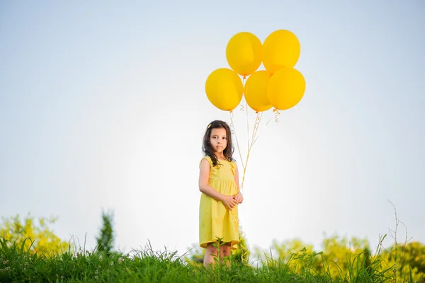 Boldog lány-sárga léggömbök — Stock Fotó