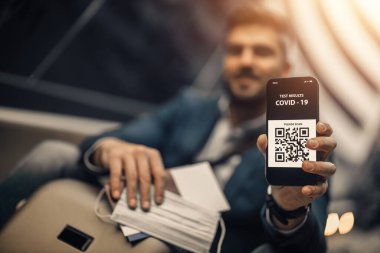 Seyahat süresi. Covid-19.Bir salgın sırasında güvenli dinlenme kavramı. Gezgin havaalanında aşı belgesi gösteriyor..