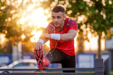 Genç sporcu bacaklarını açıyor, sabah antrenmanına hazırlanıyor. Fitness, insanlar, spor ve yaşam tarzı konsepti.