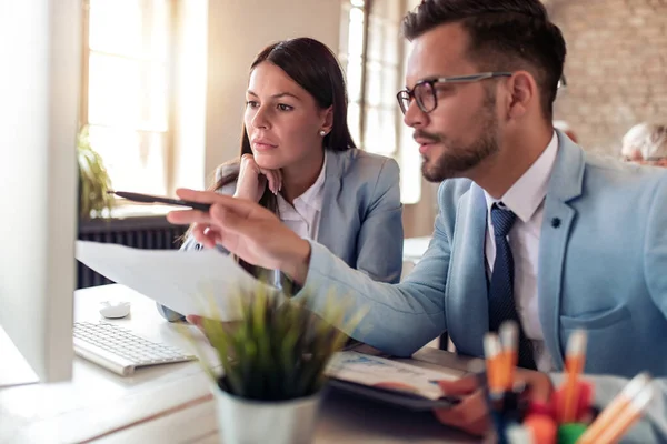 Ofisteki yeni projede birlikte çalışan iki iş arkadaşının resmi.