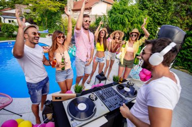Bir grup arkadaş havuz başında eğleniyorlar. Bir DJ 'in çaldığı müziği dinliyorlar..